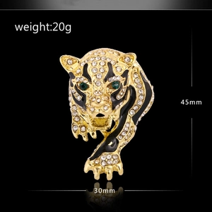 Macro detail of leopard brooch with green gemstone eyes and dimensions of 45mm by 30mm