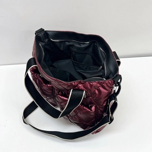 Burgundy quilted puffer shoulder bag with metallic finish and spacious interior