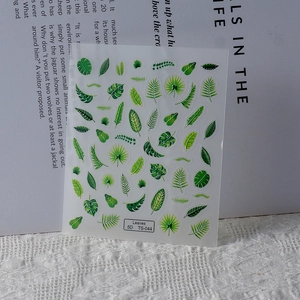 Macro view of green tropical leaf 5D embossed nail art stickers on knit background