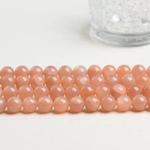 Polished peach sunstone round beads arranged neatly for DIY jewelry making and crafting
