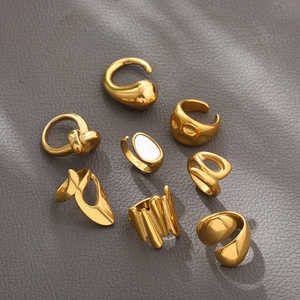 Macro shot of 18K gold plated titanium rings with mother of pearl on grey leather surface