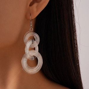 Close-up of geometric hollow spiral metal earrings worn by a model for a stylish look