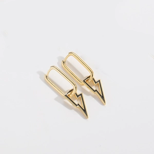 Detail of golden lightning bolt charm earrings with hoop closure on white background