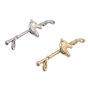 Detailed close-up of horse head brooches in polished gold and silver finishes
