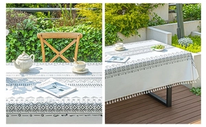 Detail of bohemian cotton linen tablecloth featuring black geometric patterns and tassels