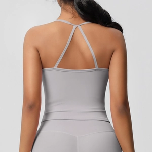 Dettaglio del design incrociato sulla schiena del top sportivo grigio chiaro da yoga