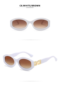 Detailed view of white oval sunglasses with brown gradient lenses and gold temple accents