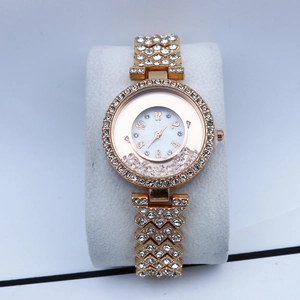 Detail of rose gold fashion watch with crystals, quicksand beads and a numeric dial