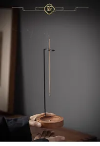 Minimalist wooden and metal incense burner with a suspended stick and thin smoke