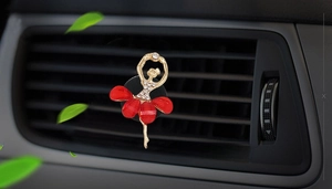 Detail of red rhinestone ballet girl car air vent clip on a black dashboard vent