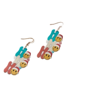 Christmas HO HO HO dangle earrings with smiley faces and snowflakes on white background