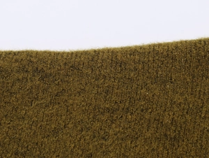 Gros plan sur un tissu en maille jaune moutarde avec texture en laine douce et fibres