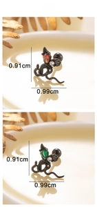 Macro shot of titanium steel snake earrings with orange and green gemstones, size 0.9cm