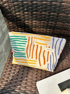 Minimalist corduroy makeup bag with abstract colorful stripes and floral pattern detail