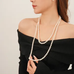 Elegant French vintage multi-layer long pearl necklace on a black sweater for women