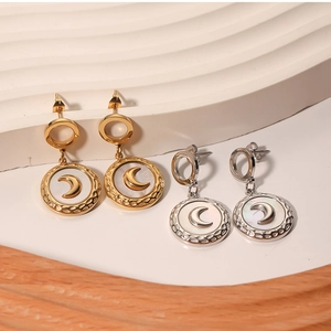 Close-up of moon earrings with mother of pearl inlay in gold and silver finish