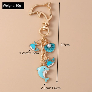 Golden keychain with blue enamel dolphin and shell charms showing size measurements