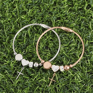 Detail of cable texture bracelets with magnetic clasp, heart charm and cross pendant