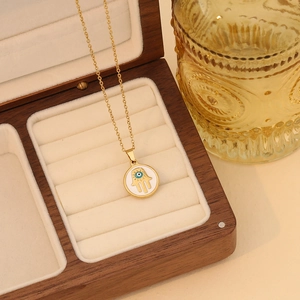 Gold Hamsa evil eye heart necklace displayed in a luxury wooden jewelry gift box