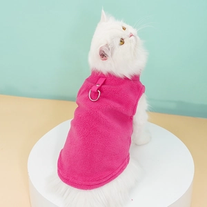 Close-up of a pink fleece cat harness vest with a metal D-ring for leash attachment