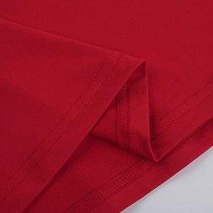 Detailed close-up of red knit fabric with professional double-needle stitching and hem finish