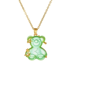 Detail of a green resin bear pendant with gold star inlay on a gold water wave chain