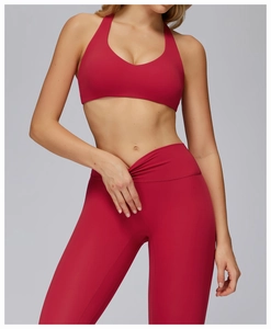 Front view of red cross-back sports bra and high-waisted yoga pants set on model