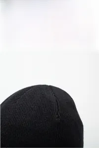 Detail of black ribbed knit beanie showing high-density thermal stitching and crown structure