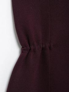 Close-up of deep purple knit top showing fine texture and cinched waist details