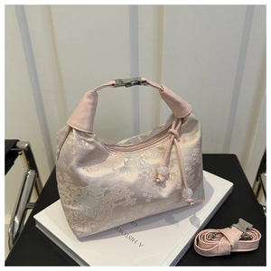 Detailed shot of pink silk handbag with gold embroidery and adjustable shoulder strap