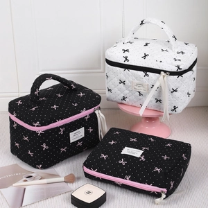 Pink polka dot bow makeup bag with quilted texture and ribbon zipper in a lifestyle setup