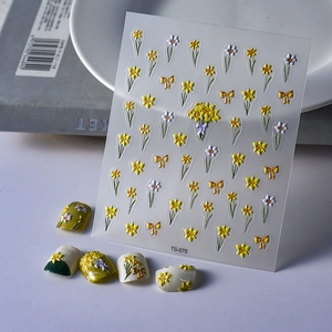 Detailed view of 3D embossed floral nail art stickers with yellow daffodil patterns.