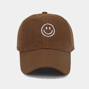 Close-up of a brown cotton baseball cap featuring white embroidered smiley face detail