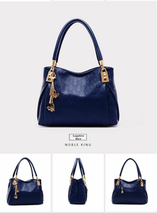 Detailed view of sapphire blue embossed leather handbag with golden butterfly charm