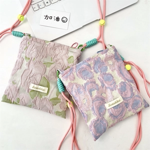 Detail of floral jacquard texture and adjustable rope strap on these mini crossbody bags