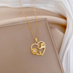 Golden elephant and sunflower heart pendant necklace displayed on white silk background