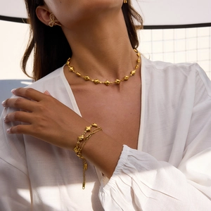 Schmuckset aus goldenem Edelstahl mit strukturierten Rautenperlen an Kette und Armband
