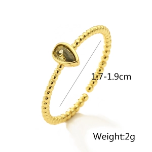 Macro detail of 18K gold plated beaded ring with pear-cut olive green gemstone