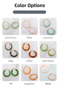 Nine variations of C-shaped resin earrings with gold edges on white fabric background