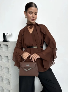 Detail of dark brown chiffon blouse featuring ruffled bell sleeves and tie-neck detail