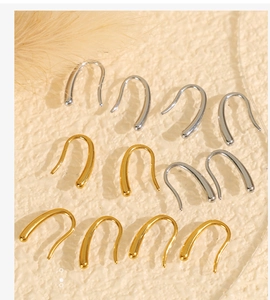 Gros plan de boucles d'oreilles minimalistes en forme de U en or et argent sur base