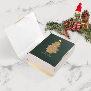 Christmas magic book gift box in dark green with a tree-shaped window and festive text