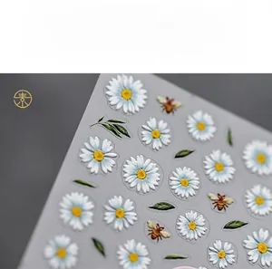 Macro detail of 5D embossed daisy nail stickers with 3D floral and bee patterns