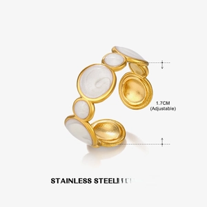 Detailed view of adjustable golden stainless steel ring with white enamel circles