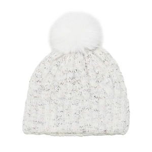 Close-up of cable knit texture and large fluffy faux fur pom-pom on winter beanie