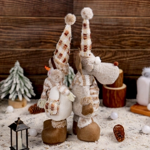 Pupazzo di neve e alce di Natale in peluche con gambe telescopiche su sfondo invernale caldo