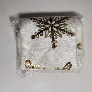 Dettaglio del tappeto per albero di Natale bianco in velluto con fiocco di neve dorato