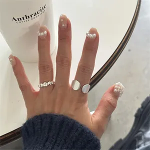 Detail of 925 sterling silver beaded ring and irregular open band on model's hand