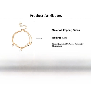 Macro detail of gold-plated double chain bracelet with red heart and zircon charms