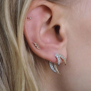 Close-up of crescent moon zircon stud earrings in gold and silver finish on ear